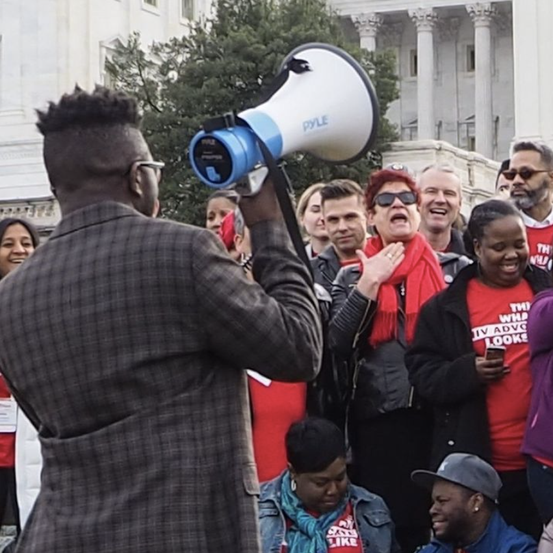 A person holding a microphone and leading a rally in Washington, DC