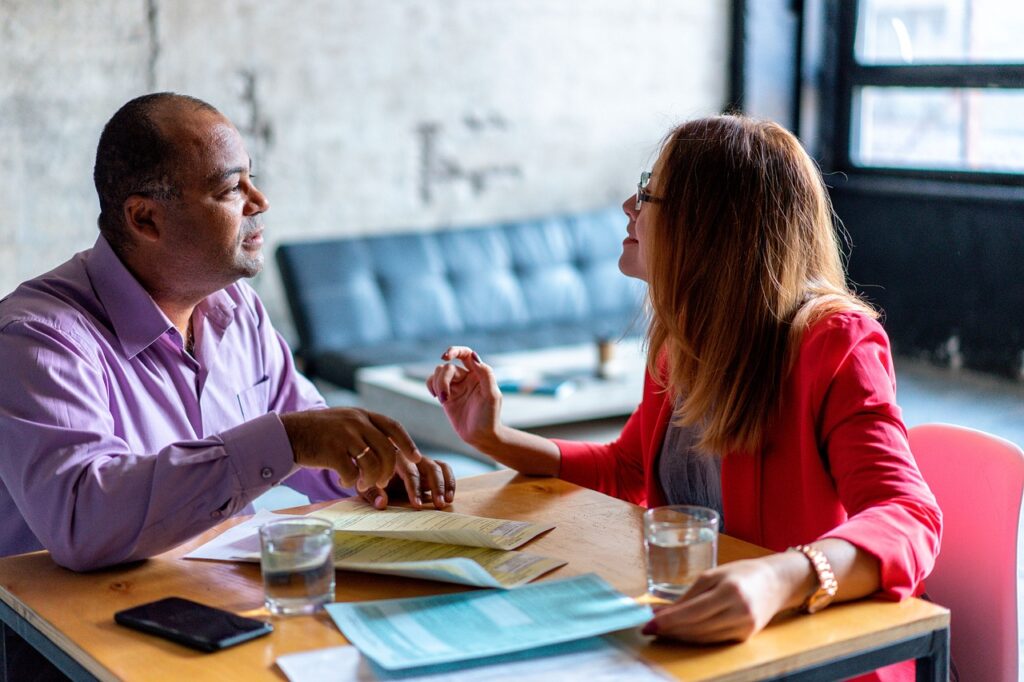 Two people sitting in a restaurant. They are in a business meeting.