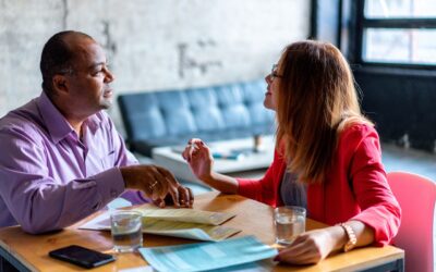 Two people sitting in a restaurant. They are in a business meeting.